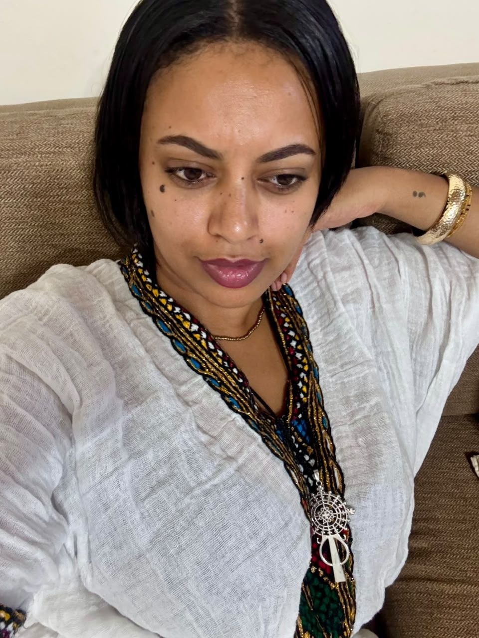 Close-up portrait of Sosi wearing a traditional beaded necklace