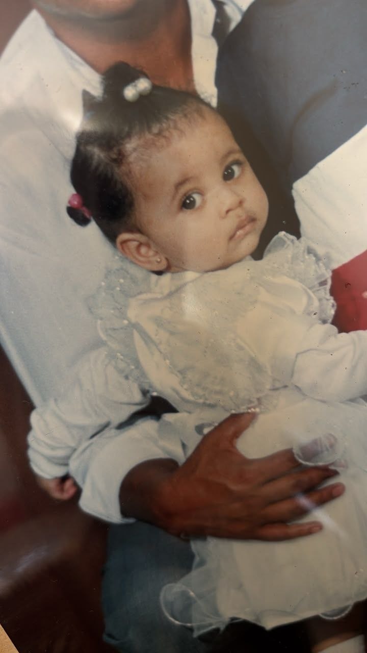 Sosi as a baby, held in her father's arms